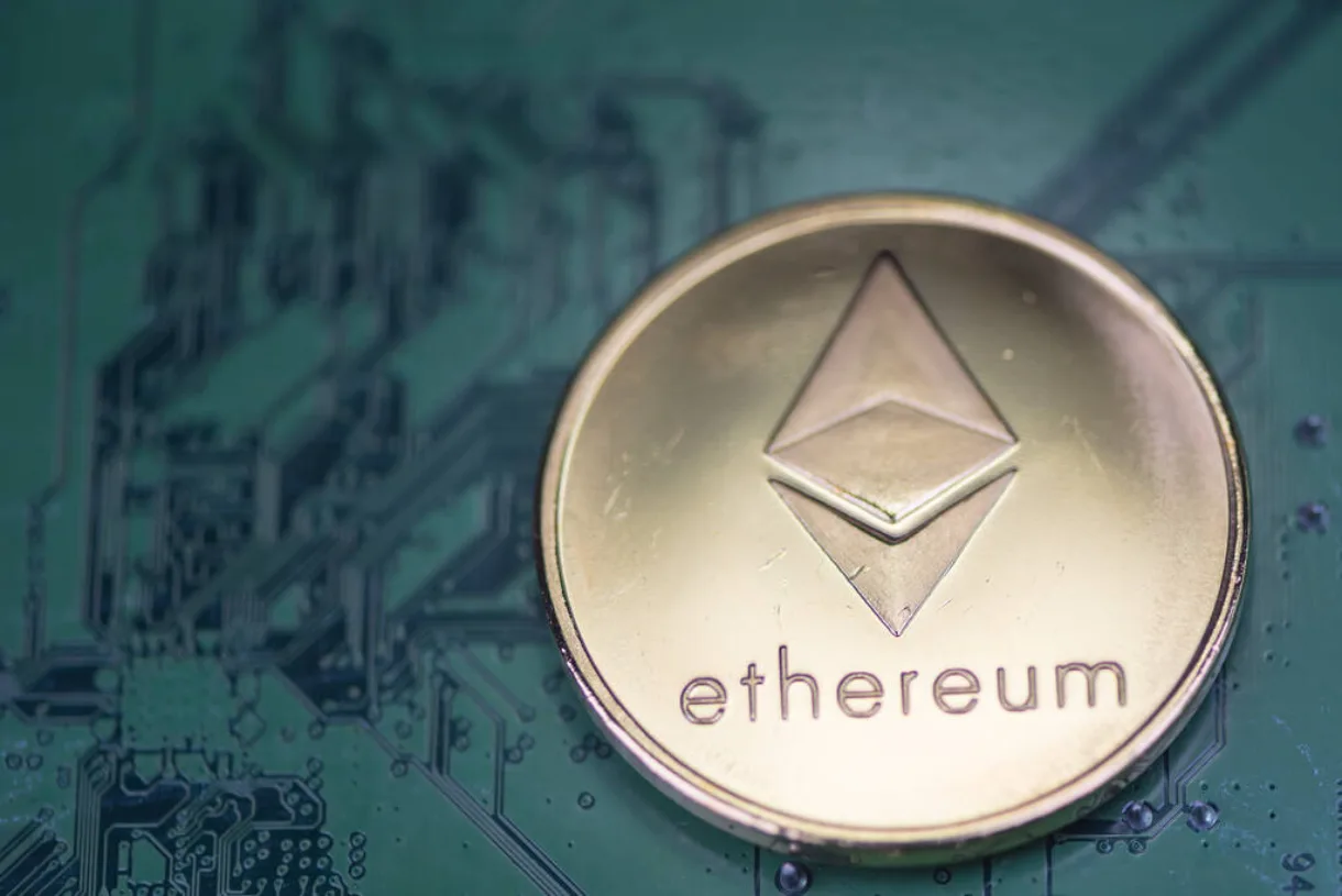 The Ethereum coin in the foreground of what looks like an electronic board.